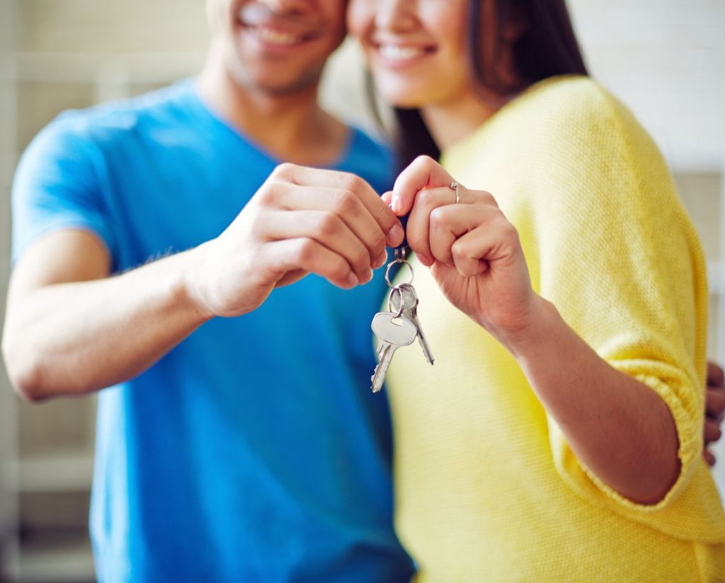 id theft buying a house couple holding a key